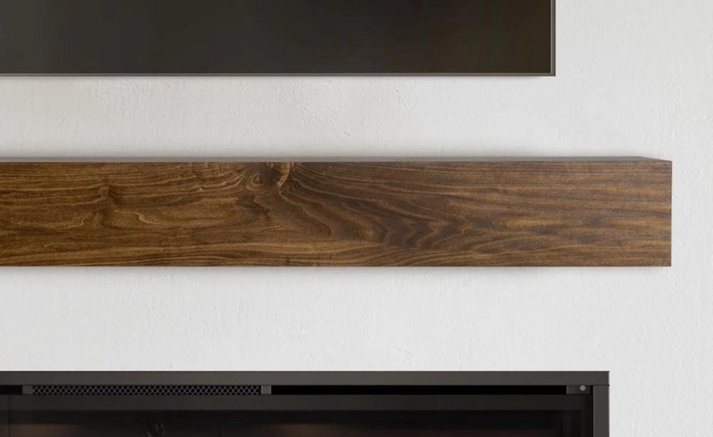 Close up of wood mantel above fireplace and below a television.