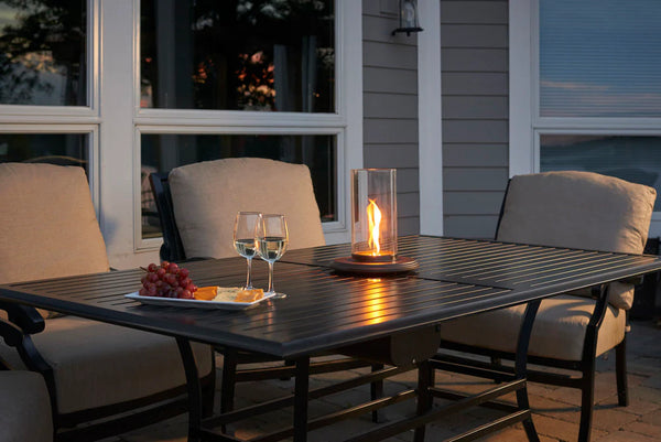 The Intrigue Tabletop Gas Outdoor Lantern on top of an outdoor dining table.