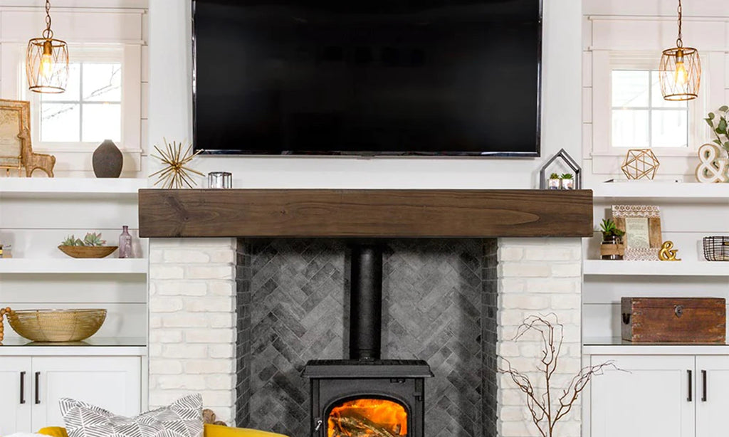 Wood slab style mantel over an ornate fireplace with television over the mantel.