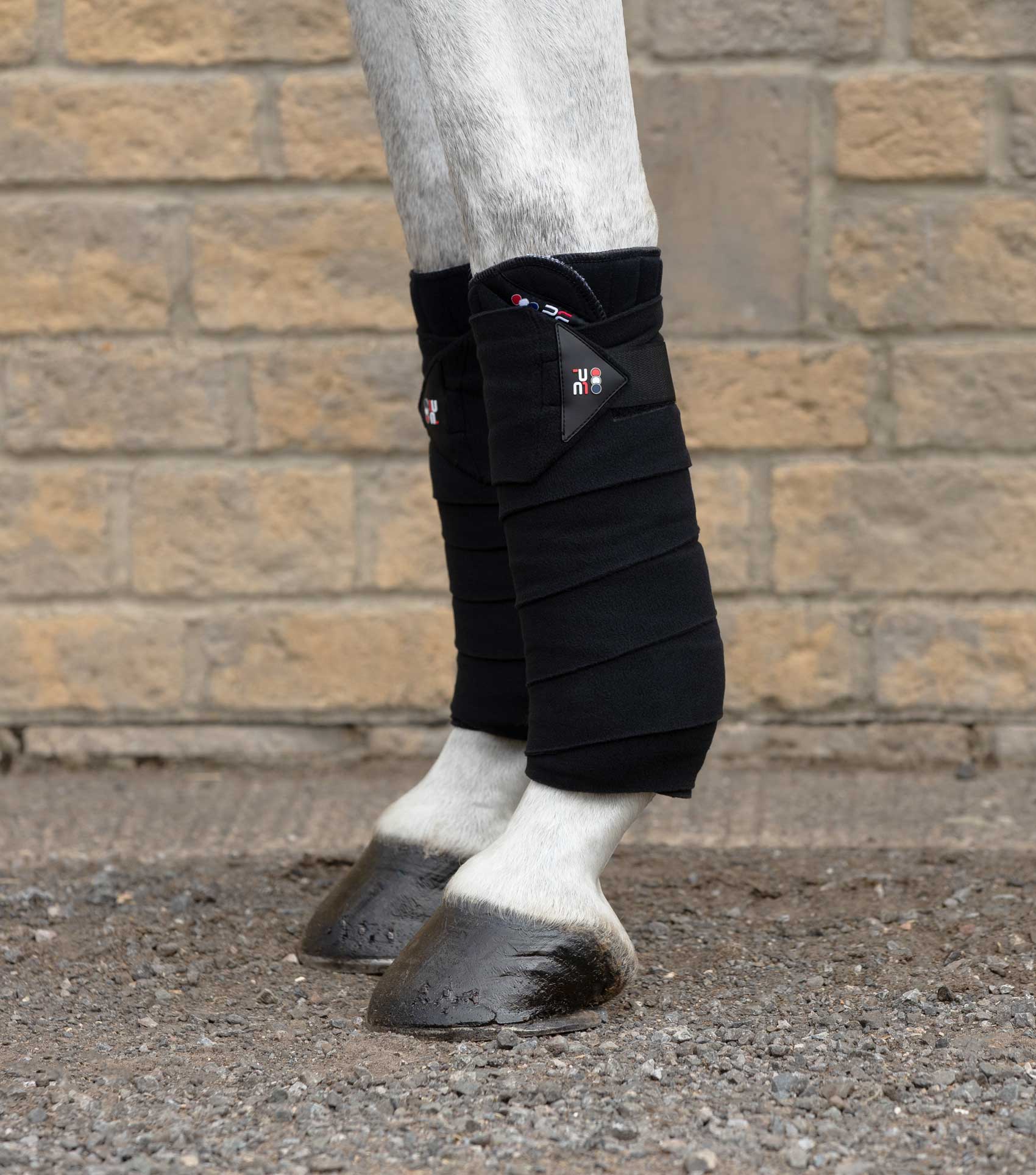 Stable Bandages using Polo Fleece Bandages in Black and Bandage Pad Wraps on front or hind legs to cover and compress tendons, offering support to stop swelling