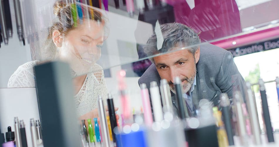 Man and women looking into a vape shop display cabinet at vape kits available.