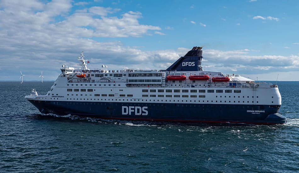 DFDS Ferry navigating through the sea near wind farm.