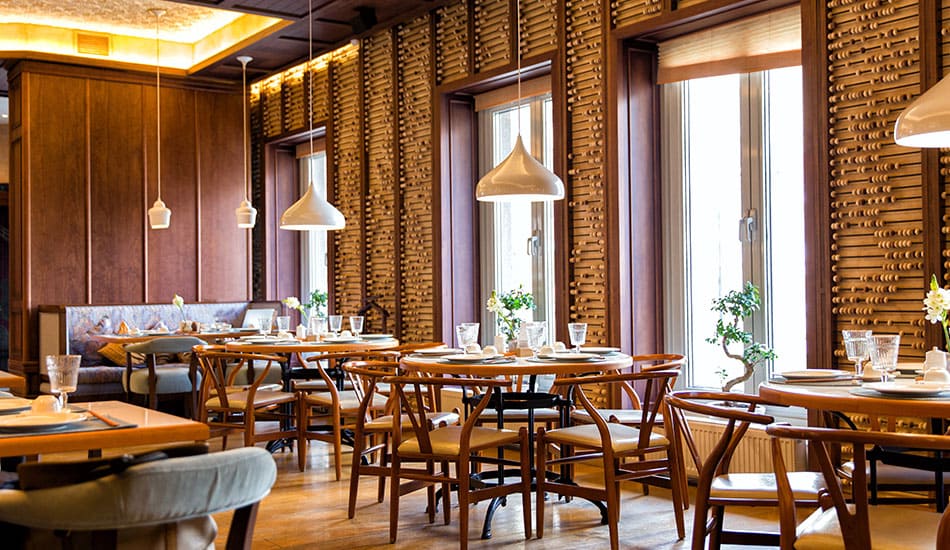 Empty restaurant showing tables and chairs set up.