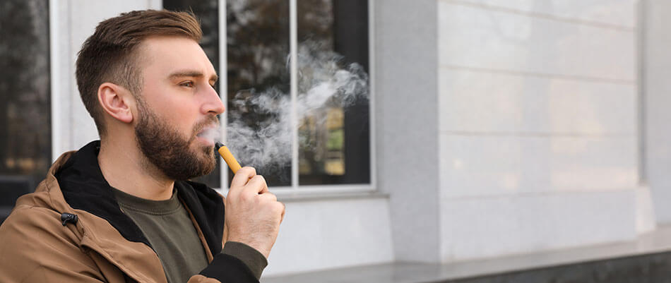 Man vaping a disposable e-cigarette