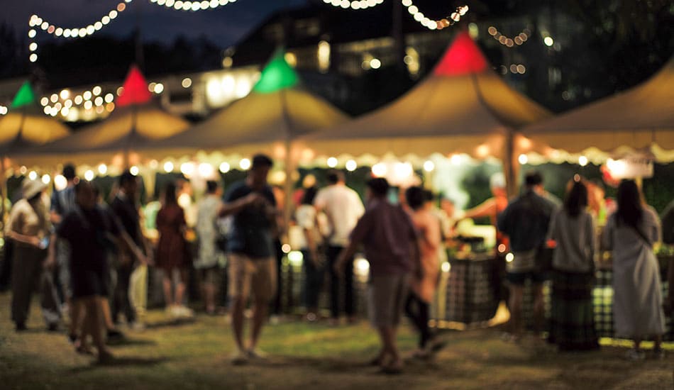 Market stalls at a music festival at night time.