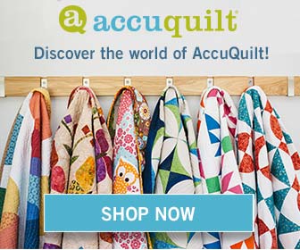 Colorful Quilts made using AccuQuilt Products, hanging up on a coat rack.