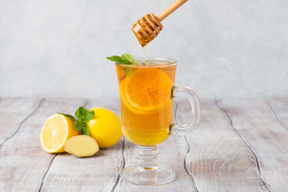 A cup of tea with honey and lemon