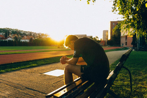 man sitting on a bench during sunset