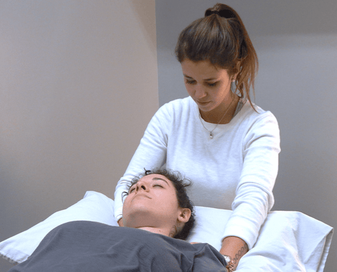 a massage therapist treating a patient, massaging shoulders