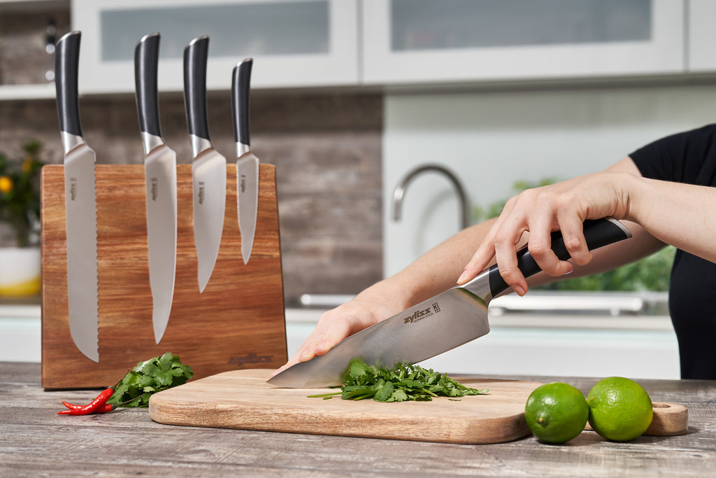 knife block with a variety of knives, one chopping herbs
