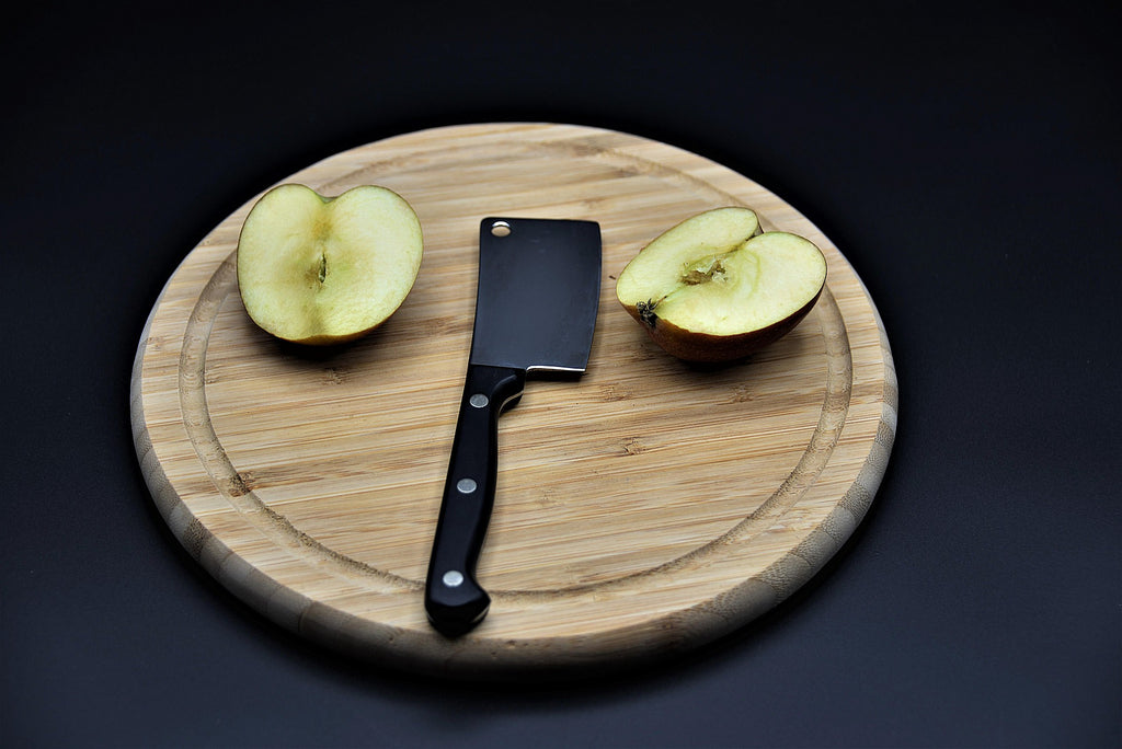 nakiri knife with apple on wooden chopping board