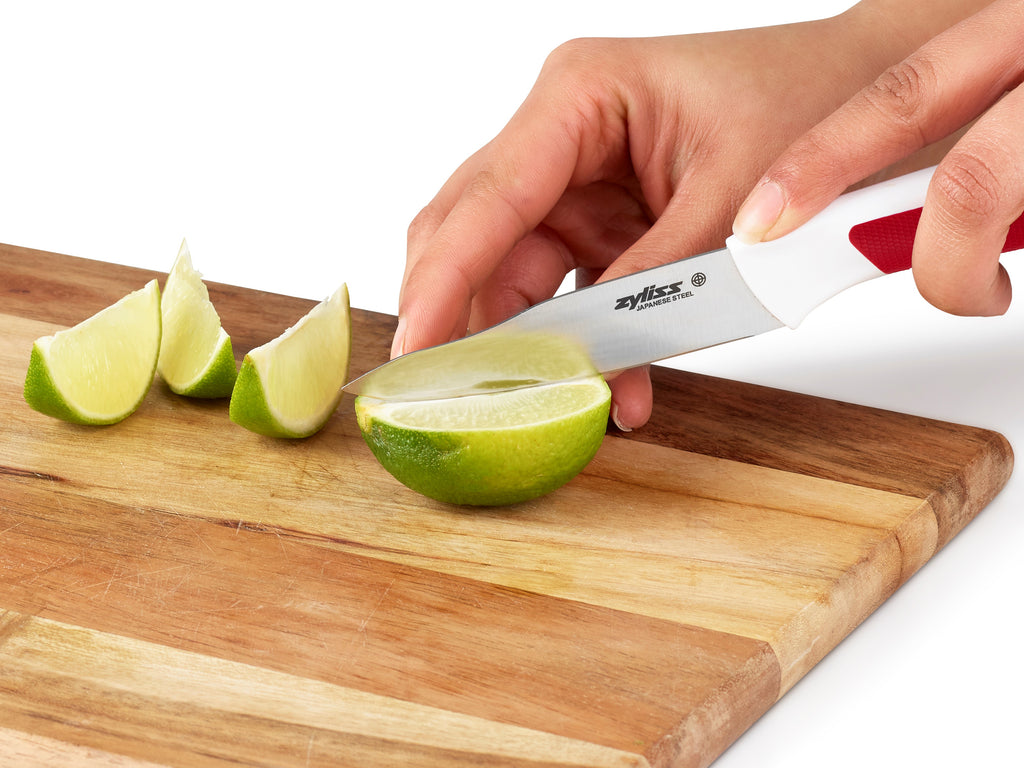 paring knife chopping a lime on a wooden chopping board