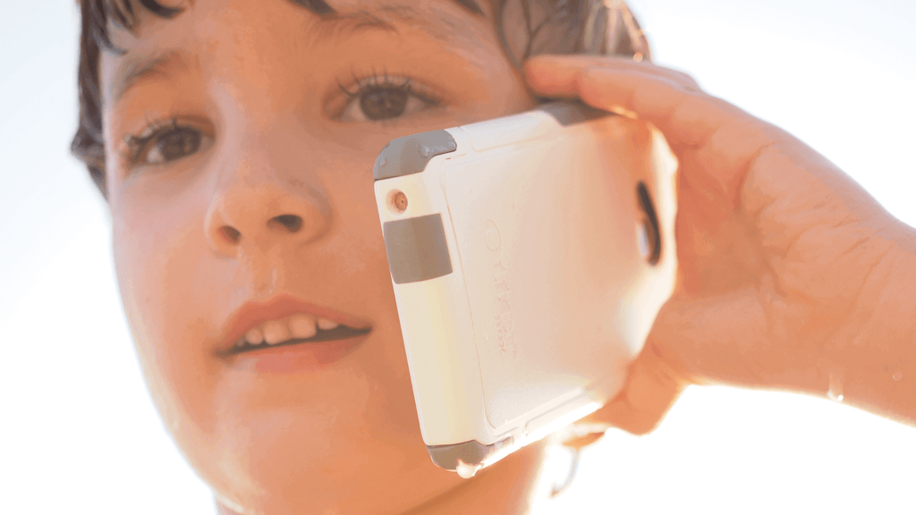 Close up of a young boy talking into a white cell phone