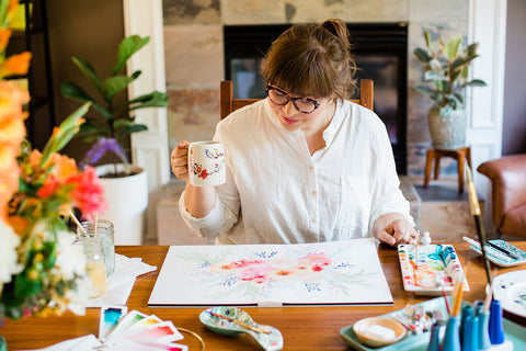 Kate looks at her painting with her coffee cup.  She doesn't look content, as if she is looking for flaws.