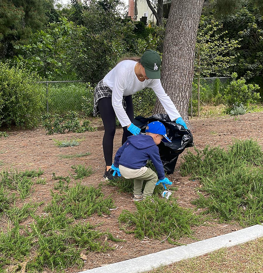 My Magic Carpet washable rugs co-founder Monica Dallyn and her son Lincoln picking up trash in a park.