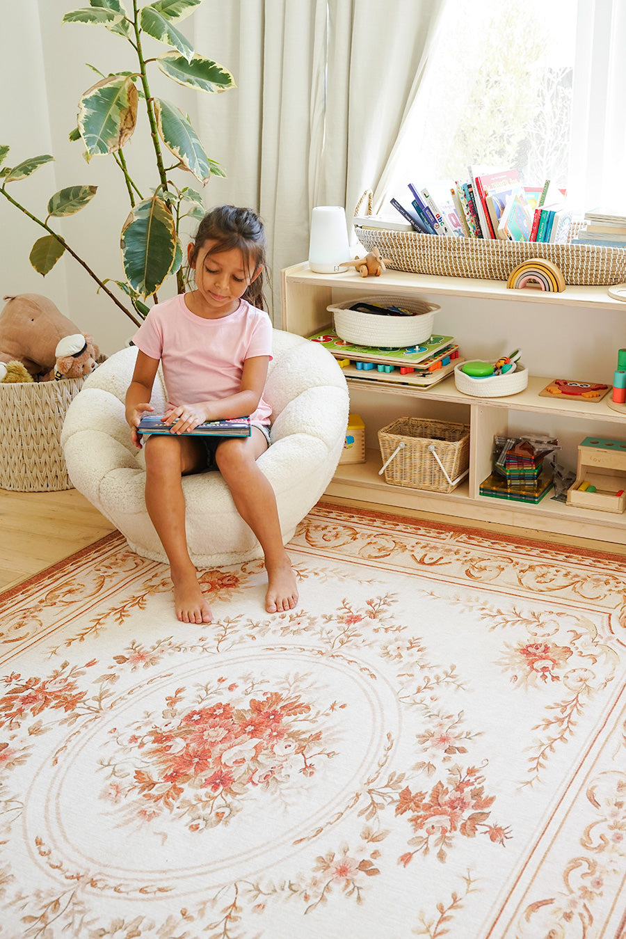 Floral medallion washable area rug on a floor in a child's playroom with a girl. 