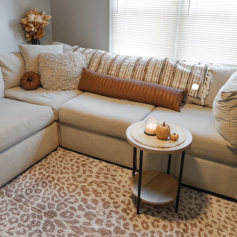 A brown sectional sitting on the Miya Leopard Brown washable rug in a living room. 