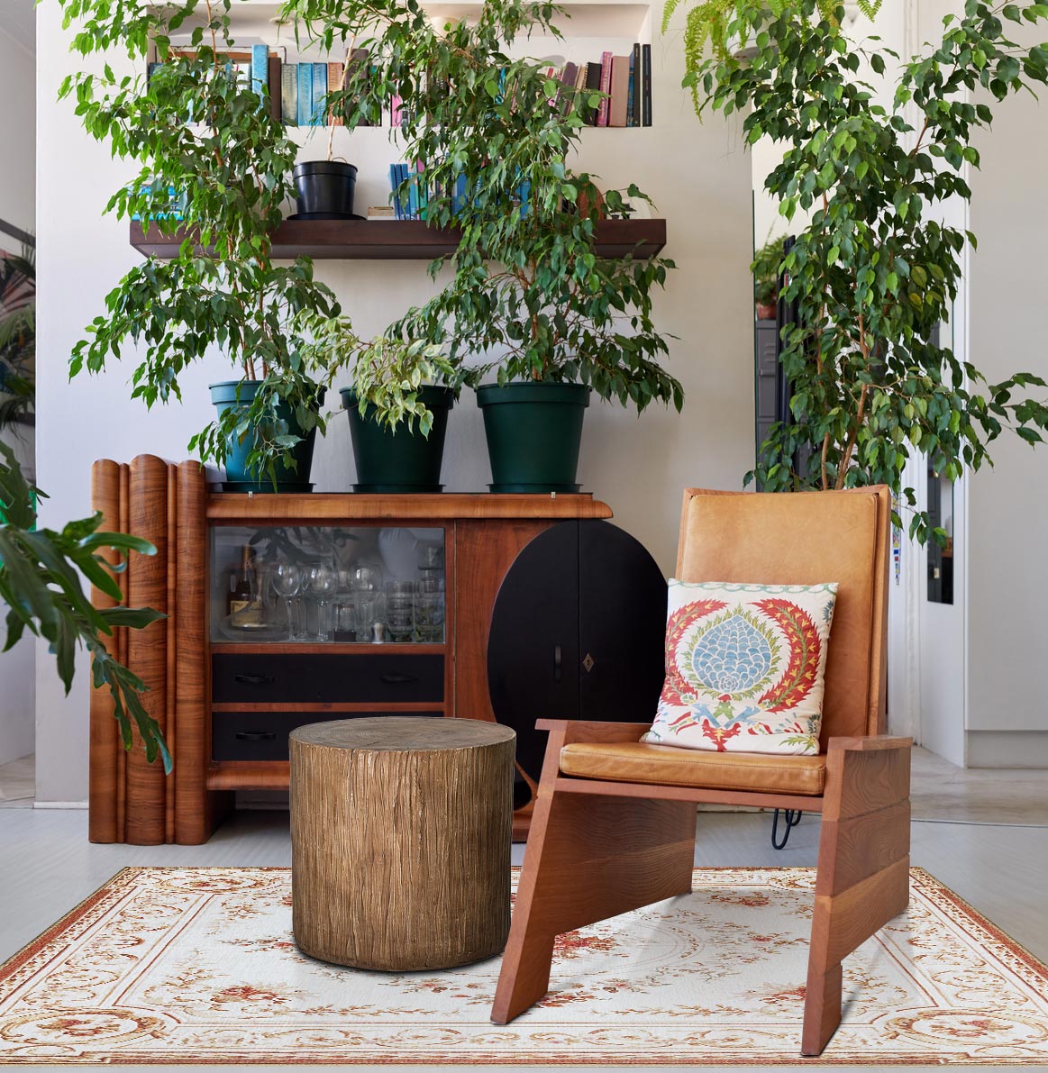 A living room with plants the My Magic Carpet Aubusson Beige washable rug and the American Art Decor boho tree stump trunk accent stool.