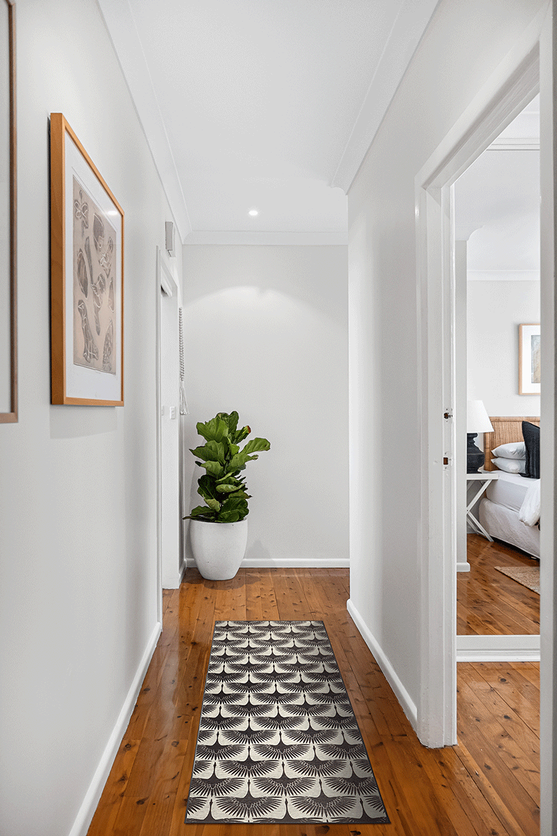 My Magic Carpet's Flock Kettle Black 2.5'x7' washable rug in a hallway.