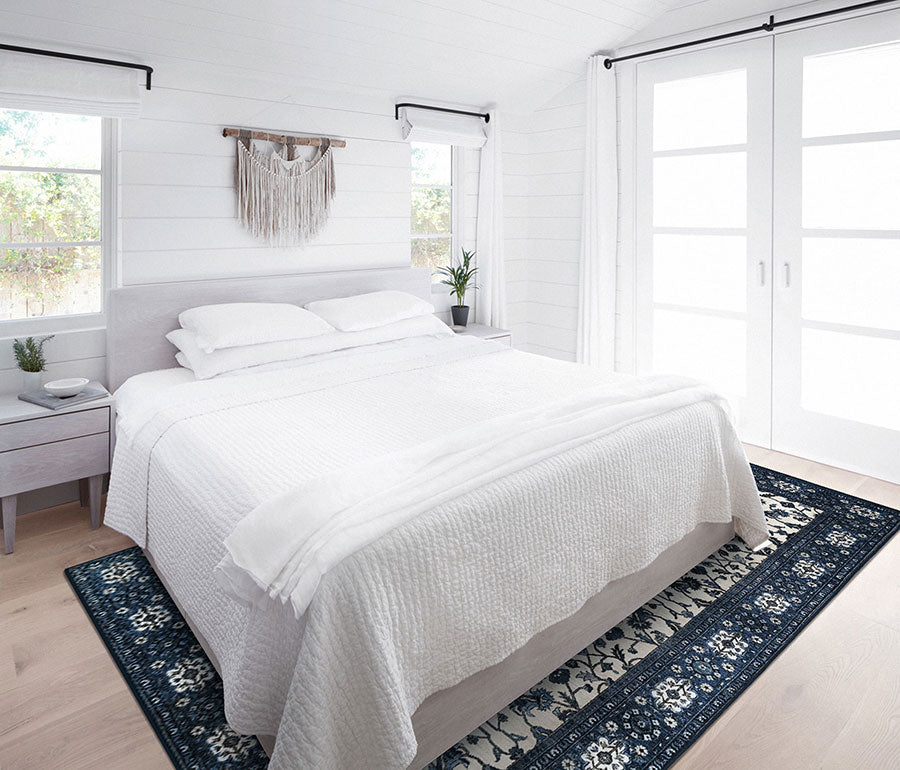 A white bedroom with My Magic Carpet's 6'x9' Ramage Blue washable rug.