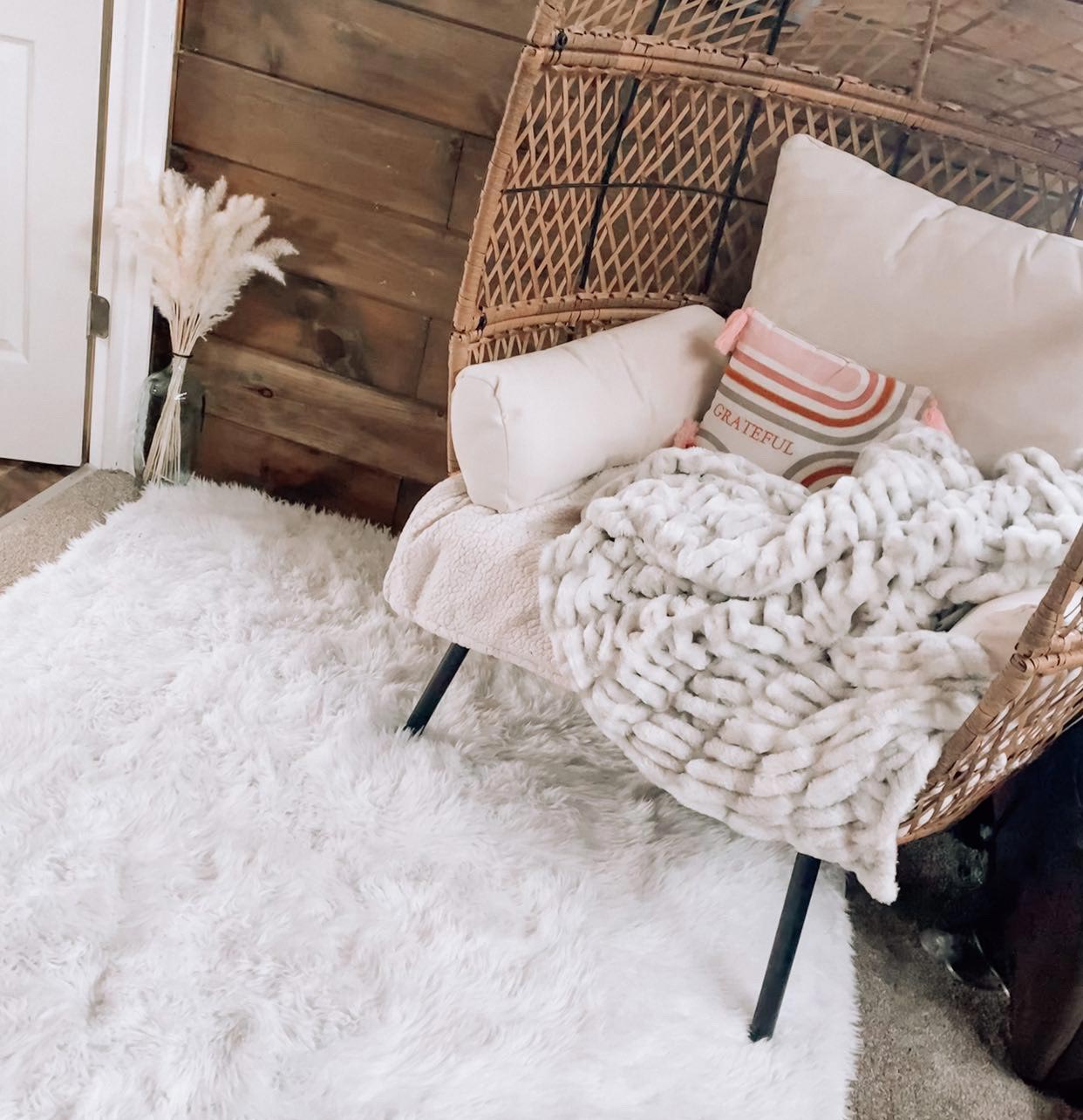 A My Magic Carpey washable shag rug in a room with a cozy chaiir and a chest of drawers.