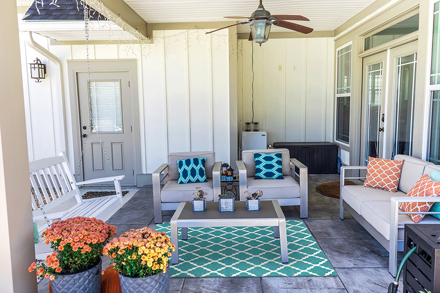 My Magic Carpet's Moroccan Trellis Teal 5'x7' washable rug placed under a table in a covered patio setting.