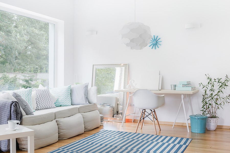 Living room by a window with a striped washable rug.