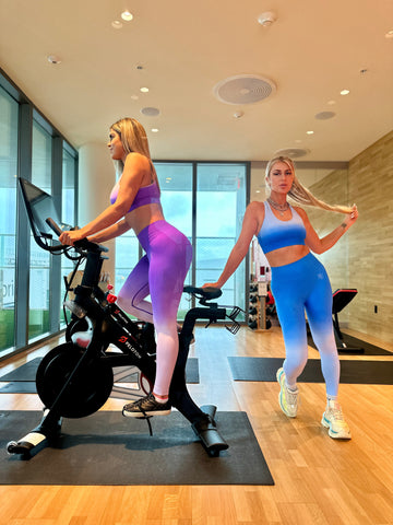 Vanity Couture's dynamic purple and blue ombre workout sets showcased by models in a gym setting. Elevate your fitness fashion with this stylish ensemble designed for both performance and a trendy gym look.