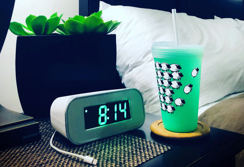 Silipint with sheep on it sitting on a bedside table representing staying hydrated at night.