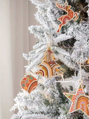 Wooden Christmas decorations with Aboriginal Art hanging on the tree by Koh Living