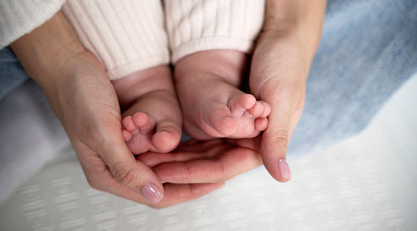 Babyvoetjes in hand van ouders