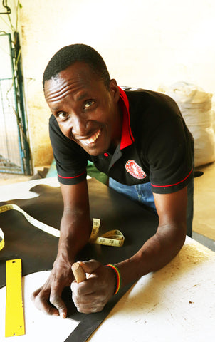 Man accurately cutting leather for handmade dog collars and leads