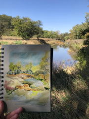 watercolor painting in foreground of landscape