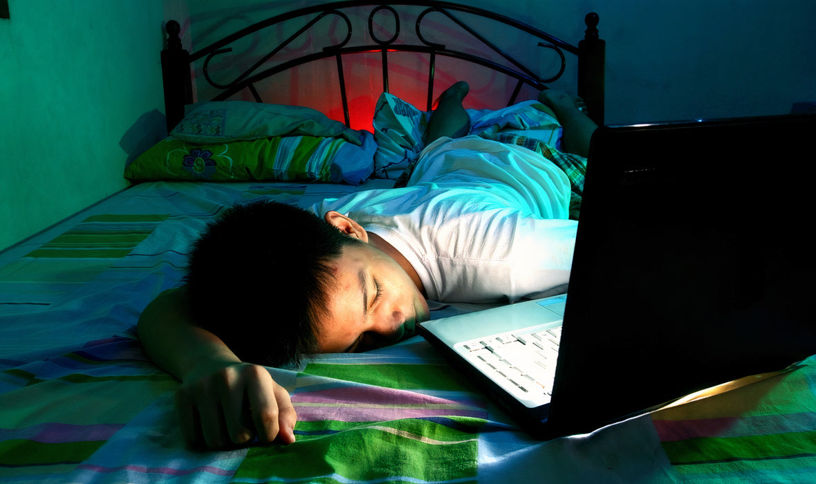 Jeune garçon qui s'est endormi devant son ordinateur
