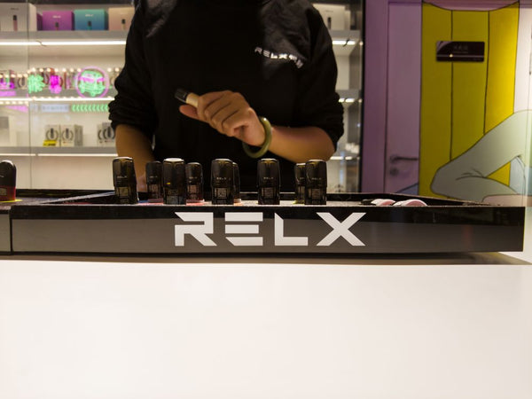 Interior toko vape RELX, dengan berbagai produk yang dipajang di atas meja etalase.