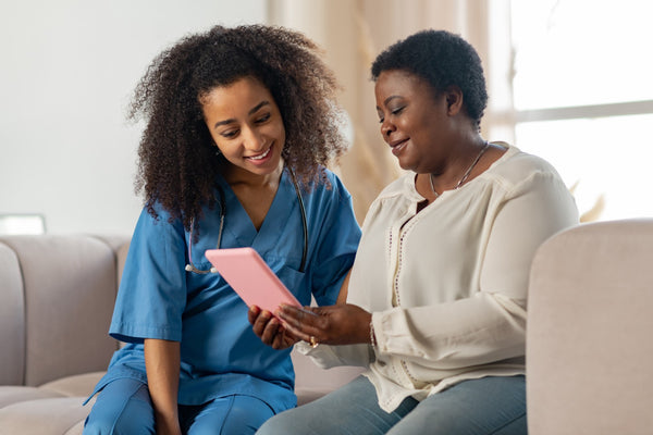 Nurse and patient chatting and looking at a tablet device