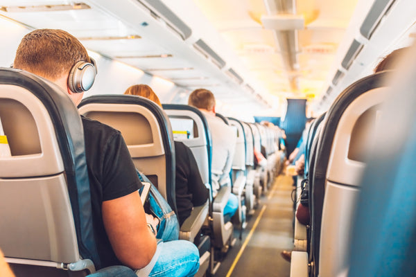 Vue vers le bas de l'allée d'un avion avec des passagers à bord