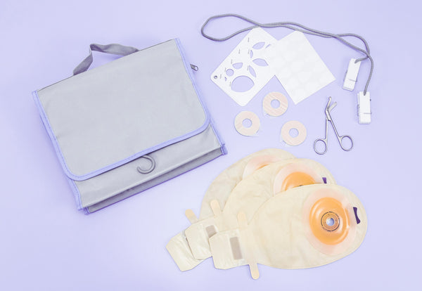 An image with an ileostomy changing kit shown including changing bag, ostomy measuring guides, ostomy bag scissors, ostomy seals and ostomy bags