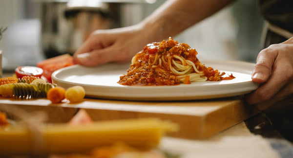Une assiette de spaghettis à la bolognaise, sur le comptoir de la cuisine, sur un plateau, sur le point d'être levée.