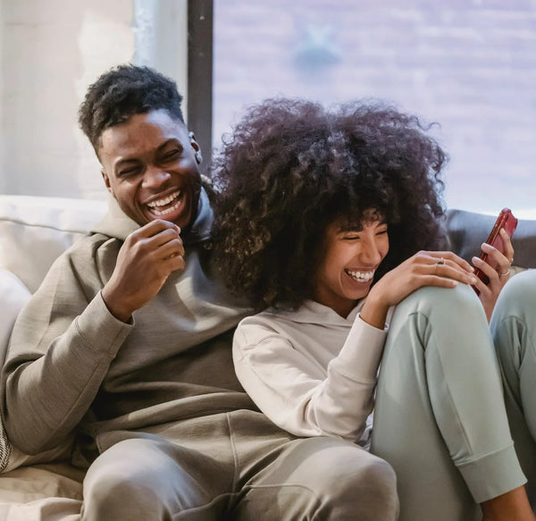 Happy couple on couch with smartphone