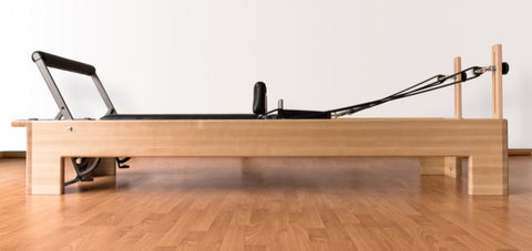 Wooden pilates reformer viewed from the side