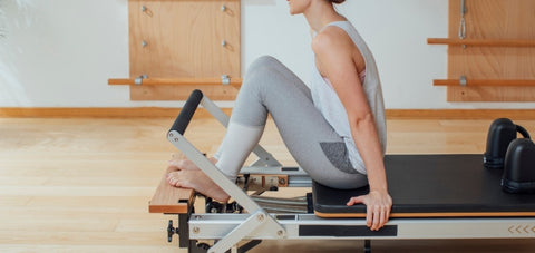 A pilates reformer with a built in platform extension at the front end