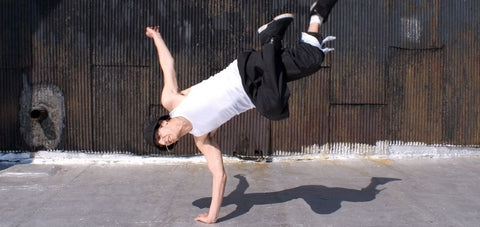 breakdancer showing a move that supports with one hand