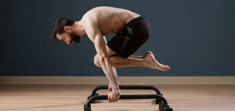 a demonstration of a man doing tuck planche exercise