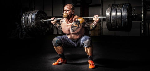 man showing squat exercise carrying heavy weights
