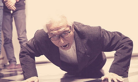 Old guy in suit struggling to do push up and doing it in the wrong form