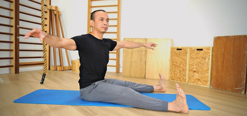 Michel Velasco demonstrating Pilates mat Spine Twist exercise