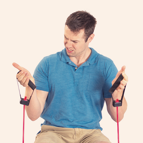 Man struggling to pull elastic bands. Signs of weakness with his program not working.