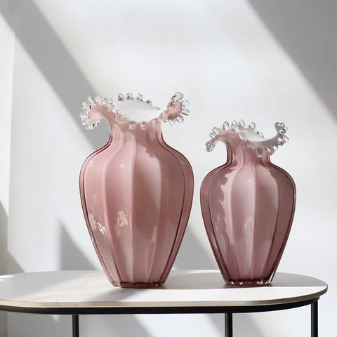 Anais Pink Beaded Vases by Allthingscurated are crafted from handblown glasses. Featuring a curvaceous body with an asymmetrical beaded rim that flares back like a collar.  Its captivating shape and romantic pink hue makes it a statement piece and a glamorous addition to your vase collection. Available in small and large size.