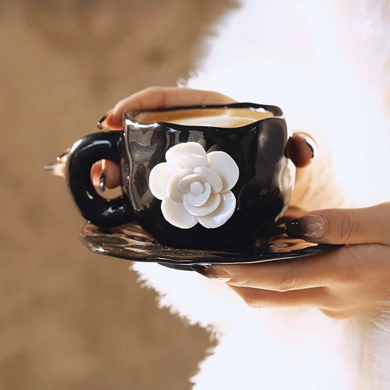 This Camellia Porcelain Cup Set / Mug by Allthingscurated features a single, significant bloom in a timeless black and white design that exudes sophistication. Its high fashion appeal makes it a perfect gift or impressive addition to your high-tea gatherings. Available as a mug or a cup set.